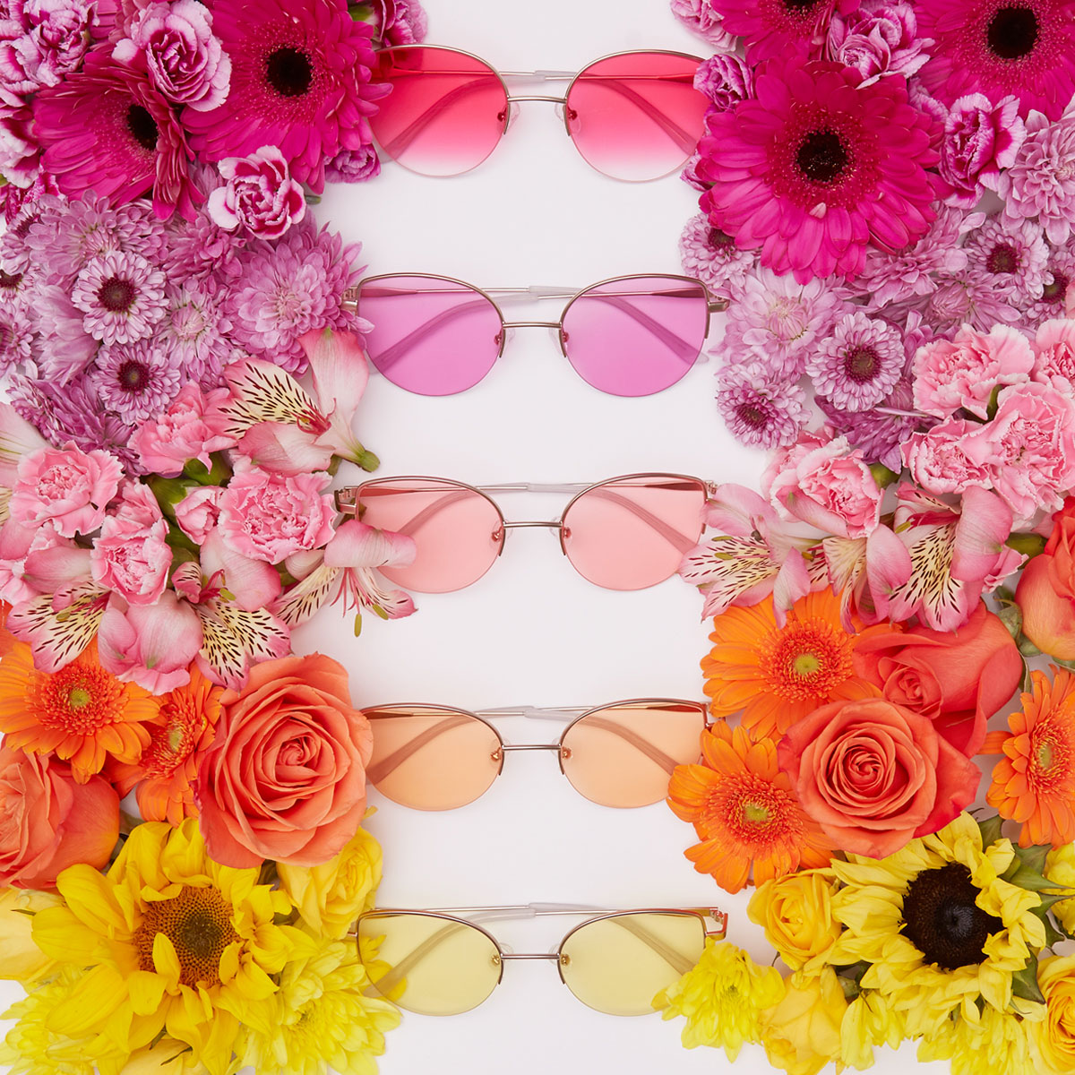 Five pairs of sunglasses with gradient lenses from pink to yellow, surrounded by matching flowers.
