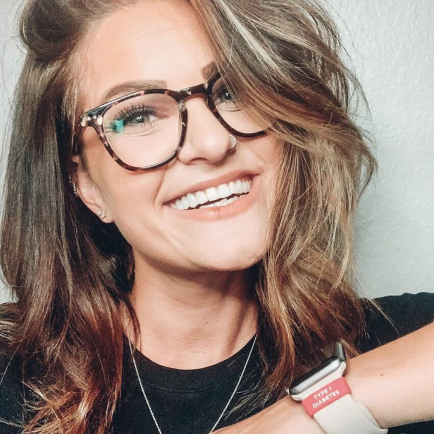 Woman wearing glasses and a smartwatch with a red band reading "TYPE 1 DIABETES".