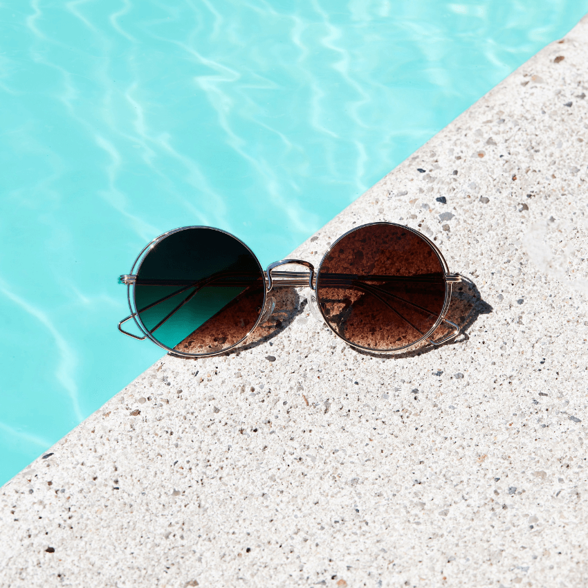 Round sunglasses with metallic frame and gradient lenses; one lens shaded blue and the other brown.