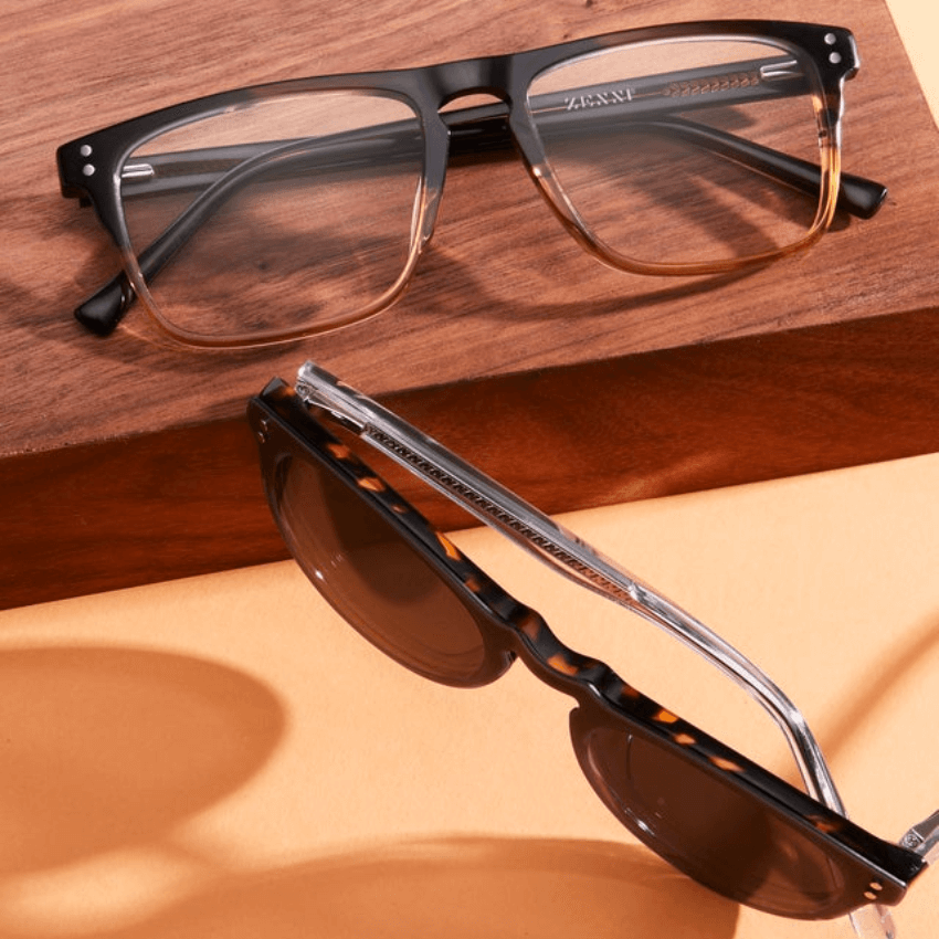 Two pairs of ZENNI glasses: one with black and brown semi-transparent frames, the other with tortoiseshell frames and dark lenses.