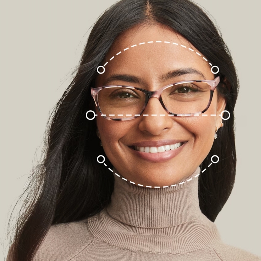 Person wearing glasses with pinkish frames and demonstration of frame fit through dotted lines and circles.
