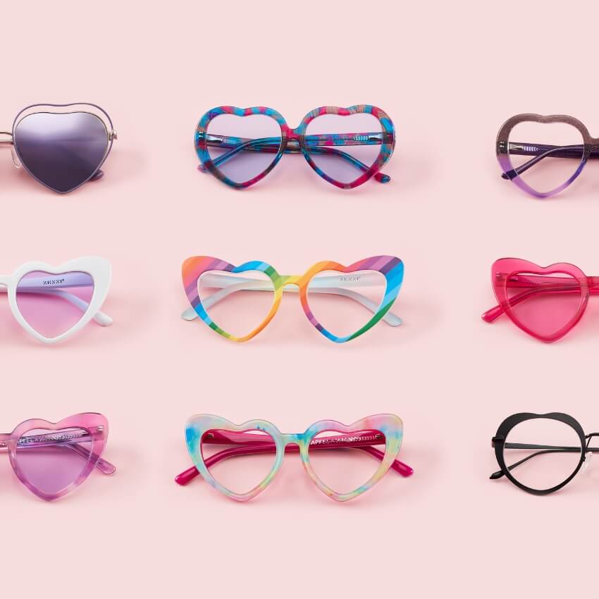 Heart-shaped sunglasses in various colors and patterns, including rainbow, pink, white, and black.