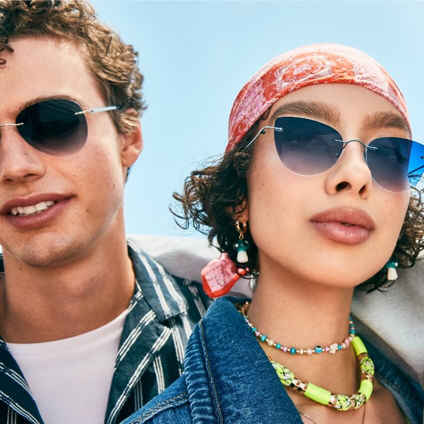 A man and woman wearing stylish blue-tinted sunglasses.