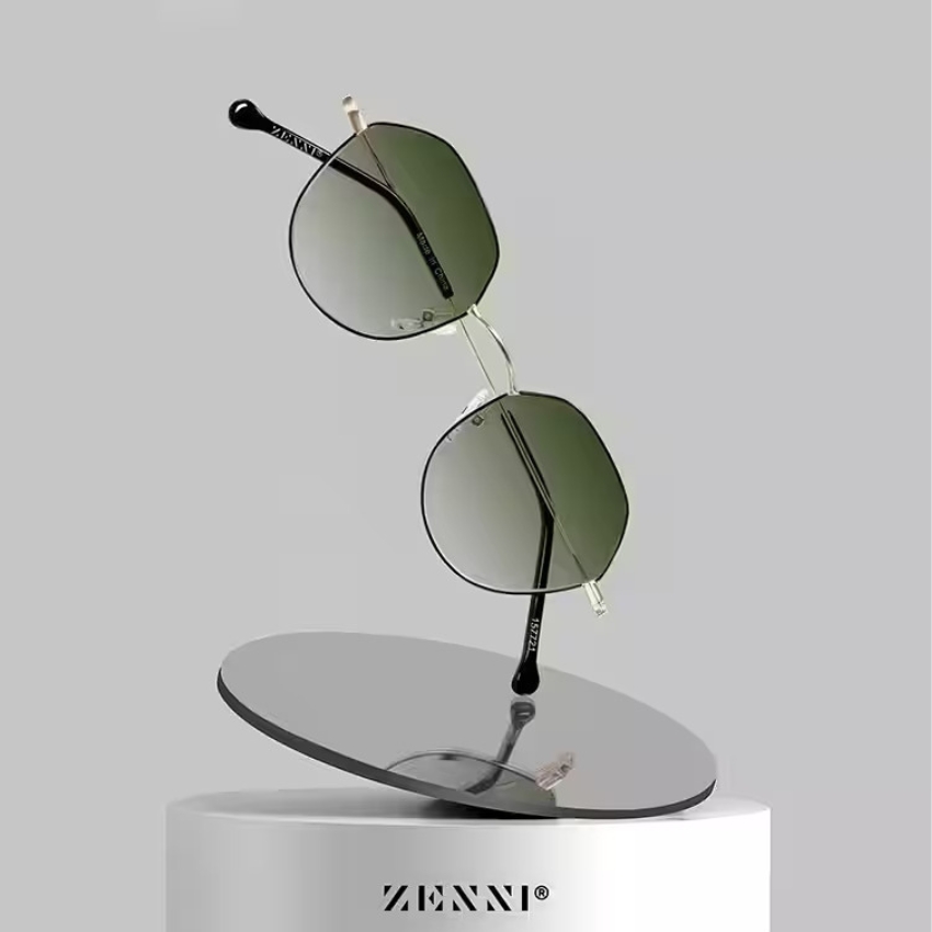 Zenni sunglasses with green-tinted lenses and black arms, displayed on a tilted, reflective pedestal.