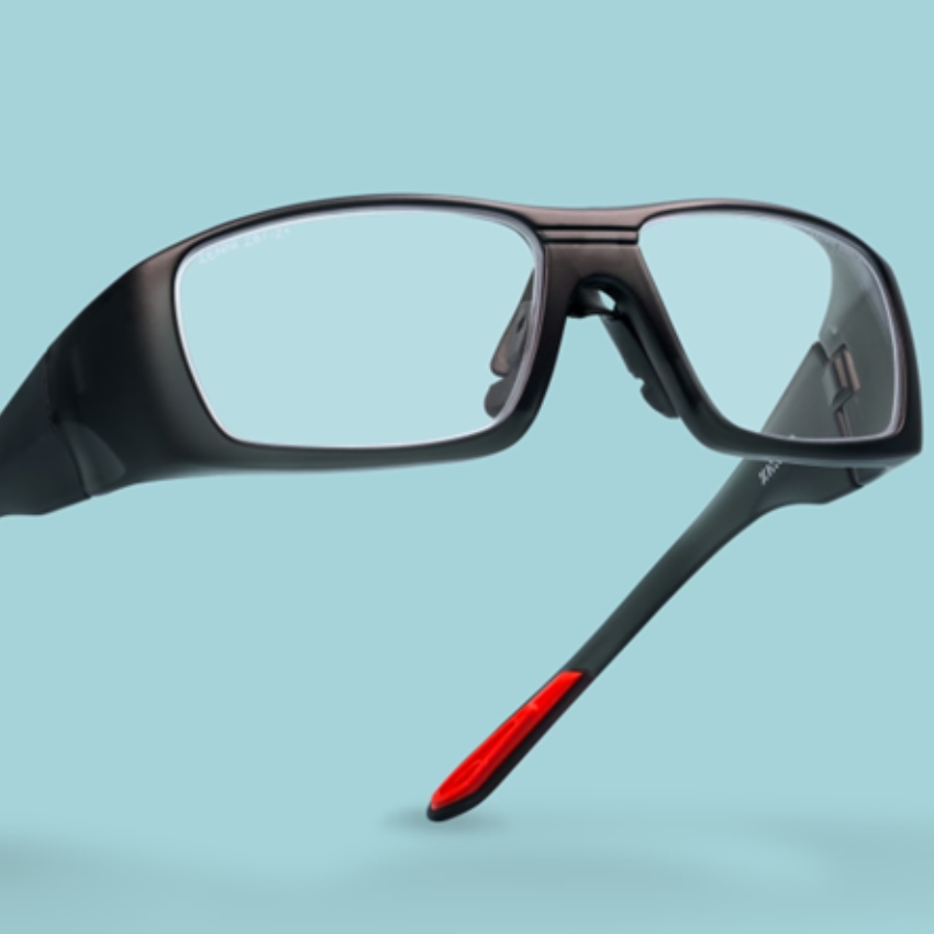 Black rectangular eyeglasses with red and black temples, floating against a light blue background.