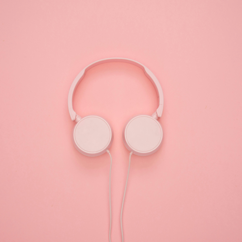 Pink over-ear headphones with a matching pink background.